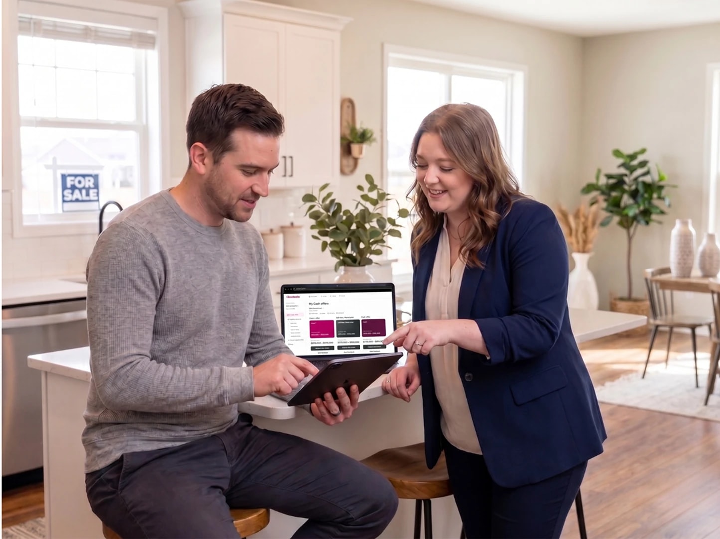 A real estate agent reviews Zoodealio cash offers with a client in a kitchen