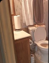 Durham bathroom before renovation, with dated wallpaper and fixtures