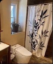 West Springfield bathroom before renovation, with dark decor and dated lighting